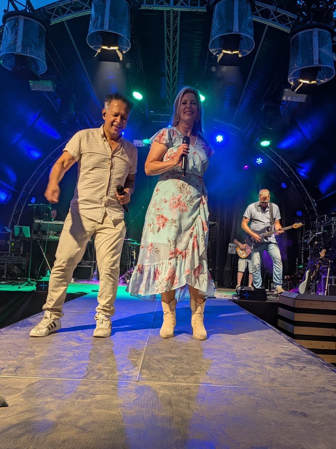 De zanger en zangeres van DaVinci samen op het podium onder de festivallampen